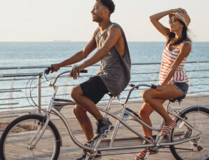 Ein Mann und eine Frau fahren gemeinsam am Meer Fahrrad