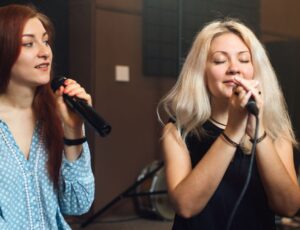 Zwei Frauen singen gemeinsam in ein Mikrofon