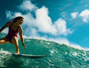 Frau auf einem Surfboard reitet die Wellen