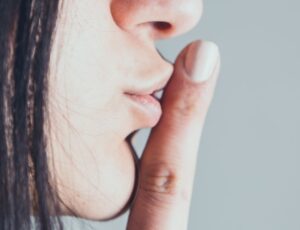 closeup girl showing silence gesture with finger on lips