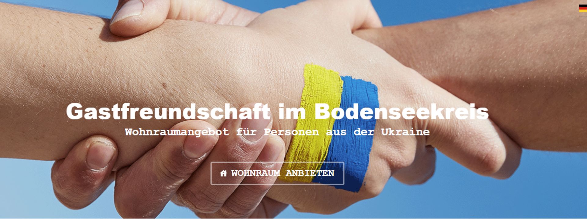 Screenshot der Webseite: Zwei Hände umfassen einander. Auf einer Hand ist die Flagge der Ukraine gemalt.