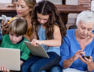 Mehr-Generationen-Familie nutzt Tablet, Notebook, Smartphone.