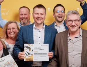 Team aus Markt Zeitlofs präsentiert Urkunde zum Fakten-Freitag beim Staatsanzeiger Award 2025