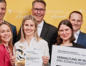 Gruppe mit Urkunde und Projektplakat zum Drei-Zonen-Konzept des Rems-Murr-Kreises beim Staatsanzeiger Award 2025.
